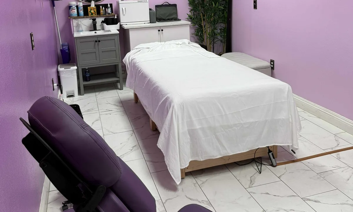 Massage table dressed in fresh white linens in the lavender treatment room